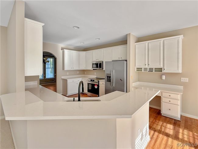 Kitchen with stainless steel appliances, light wood-style floors, white cabinetry, a peninsula, and recessed lighting | Image 6