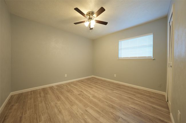 Unfurnished room featuring a textured ceiling, light wood-style floors, a ceiling fan, and baseboards | Image 8