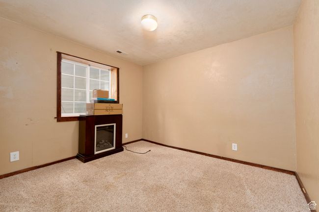 Unfurnished living room featuring carpet floors, baseboards, and a glass covered fireplace | Image 26