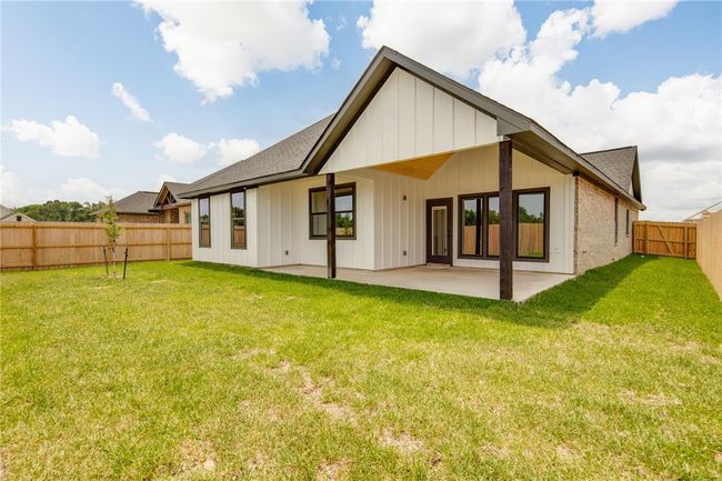 Rear view of house featuring a shingled roof, a patio area, and board and batten siding | Image 35