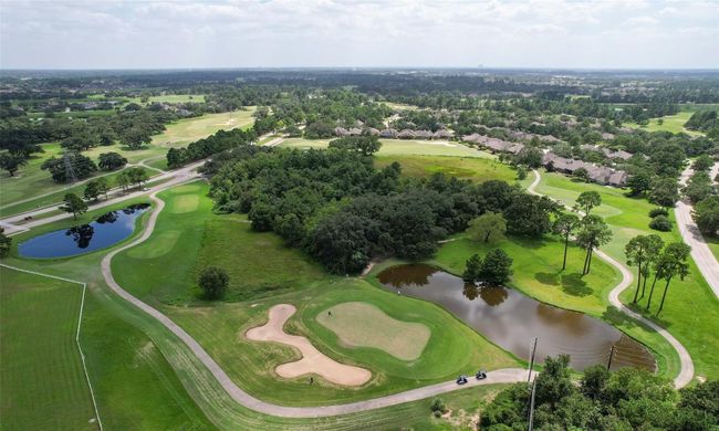 This aerial view showcases the lush golf course with winding paths, water features, and surrounding greenery. Ideal for the new or senior golfer | Image 35