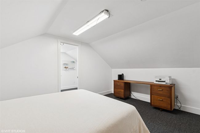 Bedroom with dark carpet, baseboards, and lofted ceiling | Image 34