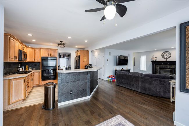 Kitchen featuring tasteful backsplash, light hardwood / wood-style floors, and black appliances | Image 6