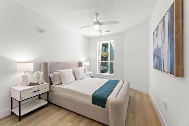 Bedroom featuring light wood-type flooring, baseboards, a ceiling fan, and visible vents | Image 8