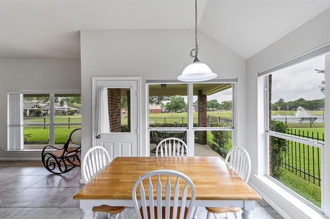 Breakfast area opens to the living room and overlooks covered patio and the lake in the backyard. | Image 8