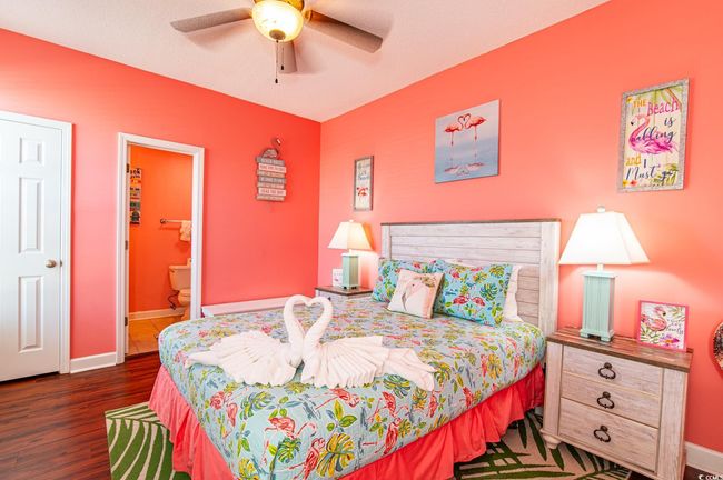 Bedroom with wood finished floors, baseboards, ensuite bath, and ceiling fan | Image 18