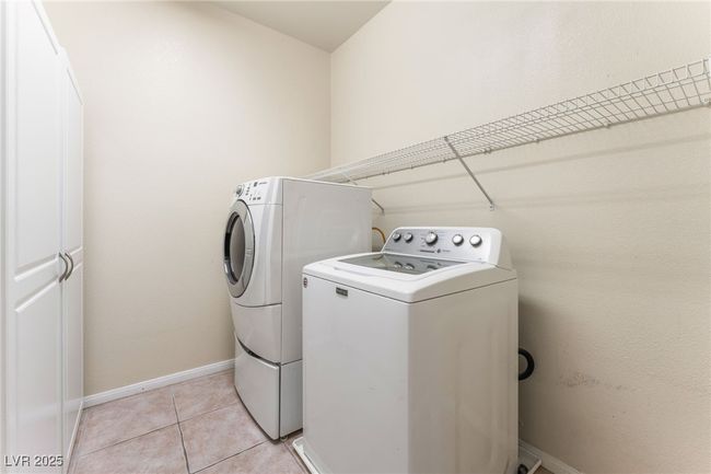 Laundry room featuring washer and clothes dryer, light tile patterned flooring, and baseboards | Image 44