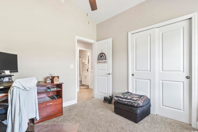 Carpeted home office featuring a ceiling fan and high vaulted ceiling | Image 18