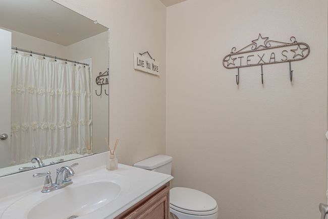 Bathroom featuring toilet, vanity, and a shower with shower curtain | Image 6