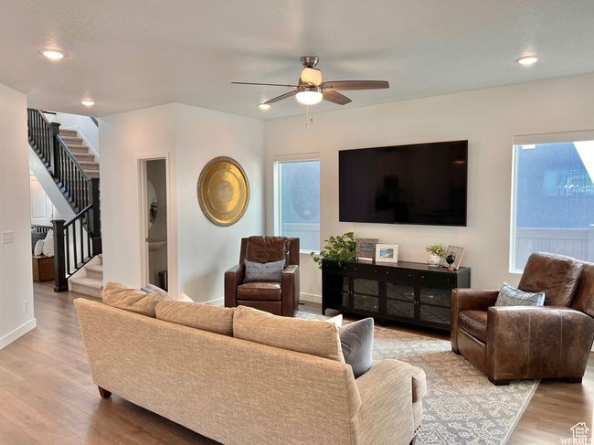 Living room featuring ceiling fan, a healthy amount of sunlight, and light wood-type flooring | Image 5