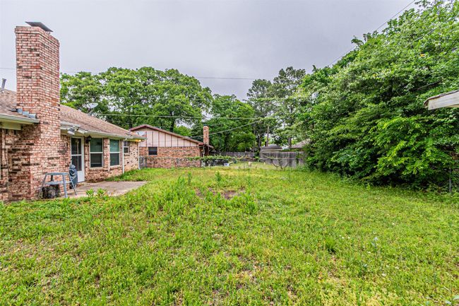View of yard featuring fence and a patio area | Image 34