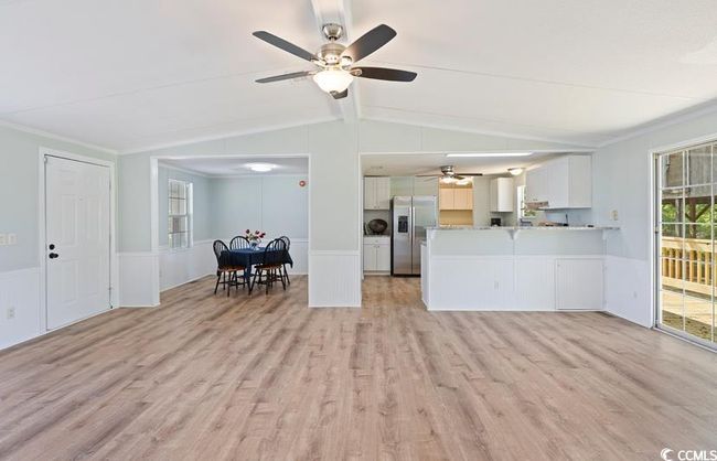 Living area featuring a ceiling fan, light wood-style floors, wainscoting, and ornamental molding | Image 9