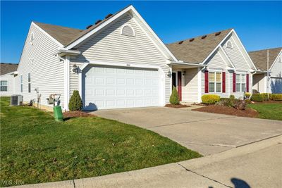 Ranch-style home featuring a garage, central AC unit, and a front lawn | Image 3