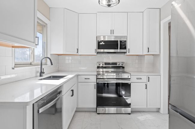 Remodeled Kitchen Including Stainless Steel Appliances, Quartz Countertops, and Tiled Backsplash | Image 6