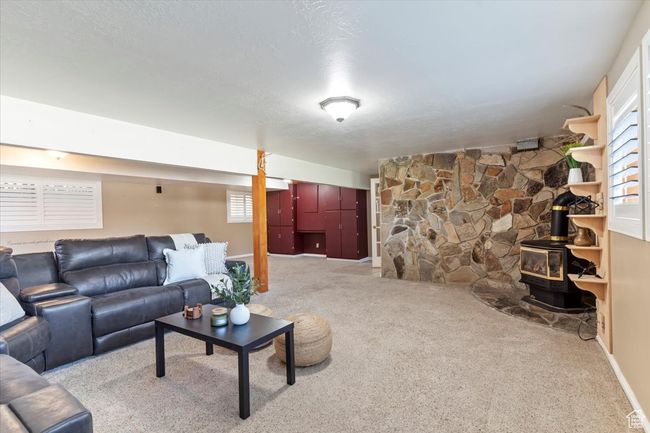 Carpeted living area with healthy amount of natural light and a wood stove | Image 16
