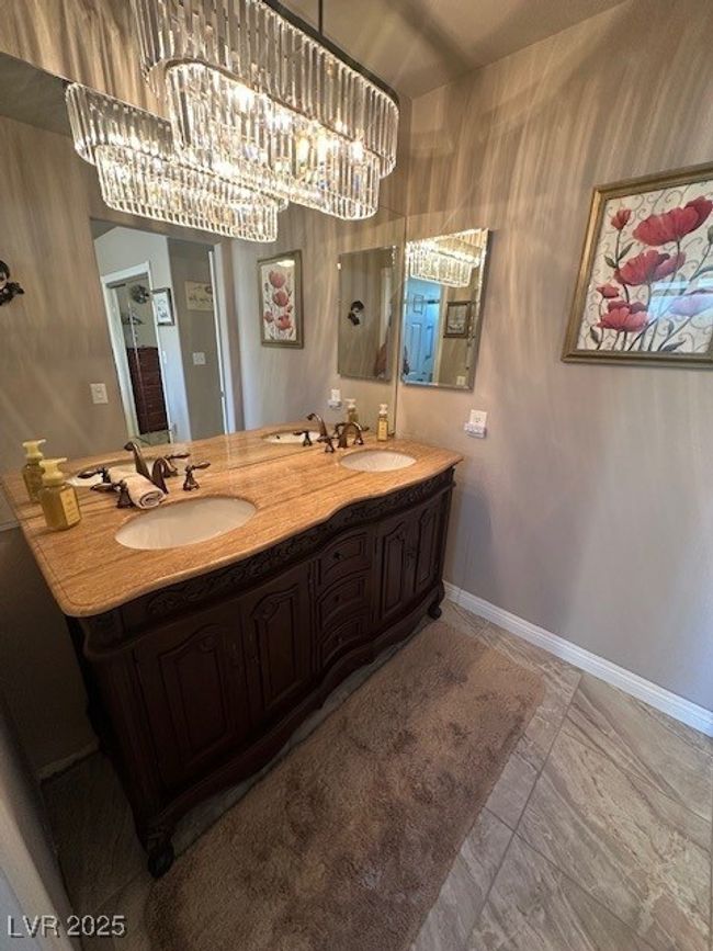 Bathroom featuring double vanity, a chandelier, and marble finish flooring | Image 10