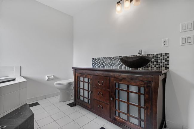 Full bathroom with backsplash, tile patterned flooring, vanity, and a bath | Image 20