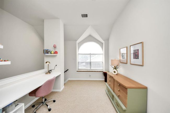 Discover endless possibilities in the versatile bonus room upstairs, easily tailored to fit your unique needs and lifestyle. Whether it’s a dedicated desk area for kids to study or a quiet spot for work, this space offers a built-in desk that adds both function and charm. | Image 24