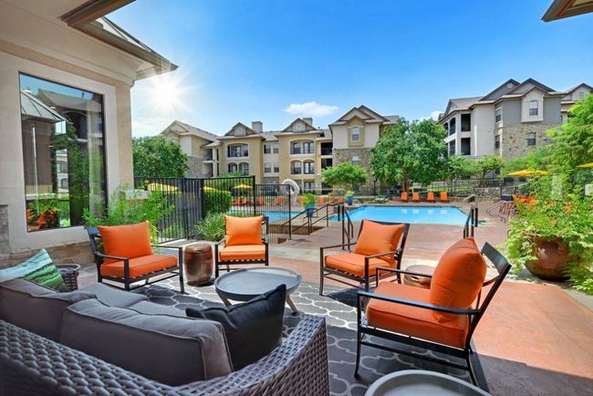 View of patio featuring fence, a community pool, a residential view, and an outdoor hangout area | Image 15