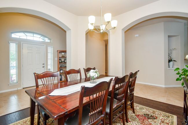 Spacious dining area with a large wooden table and chairs. | Image 4