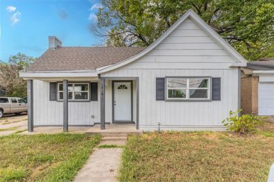 View of front of home featuring a garage, covered porch, and a front lawn | Image 1