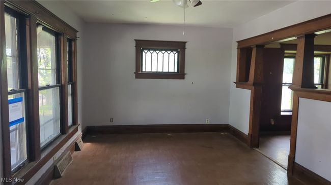 Empty room with baseboards, visible vents, plenty of natural light, and wood finished floors | Image 7