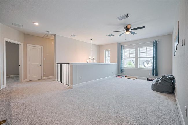 Extended view of the upstairs game room showcasing spacious layout, natural light, and modern finishes—designed for both leisure and functionality | Image 29