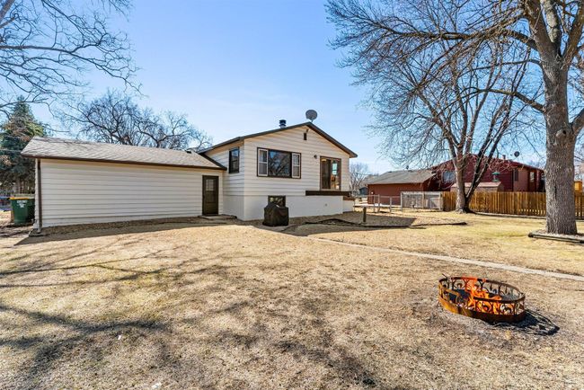 The expansive backyard is fully enclosed with chain link fencing and features mature trees and peaceful views. | Image 18