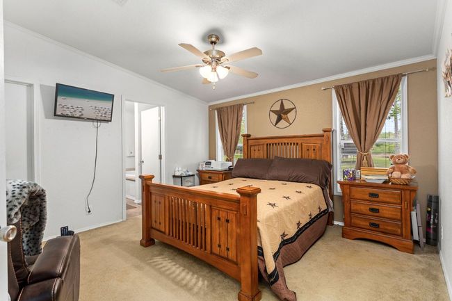 Primary bedroom with queen bed setup, carpeting, and ceiling fan | Image 22