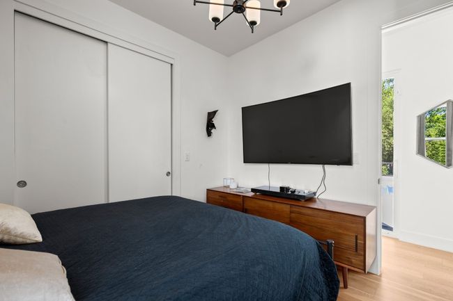 Bedroom with light wood-style flooring, a closet, and a chandelier | Image 26