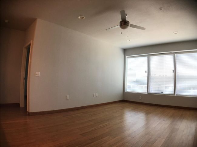 Unfurnished room featuring wood finished floors, ceiling fan, baseboards, and recessed lighting | Image 11