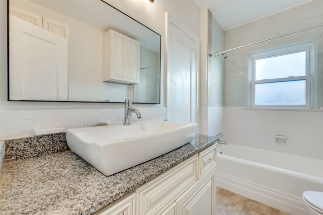 Bathroom with vanity, bathtub / shower combination, and toilet | Image 29