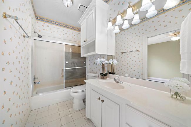 En suite bathroom has a tub/shower combo, and plenty of cabinets for storage. | Image 34