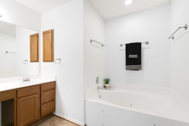 Spacious primary bathroom featuring a luxurious deep jetted tub, perfect for relaxation. | Image 32