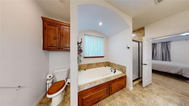 Full bath featuring toilet, ensuite bath, a tub with jets, and a stall shower | Image 36