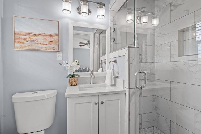 Bathroom with toilet, a stall shower, vanity, and a ceiling fan | Image 20