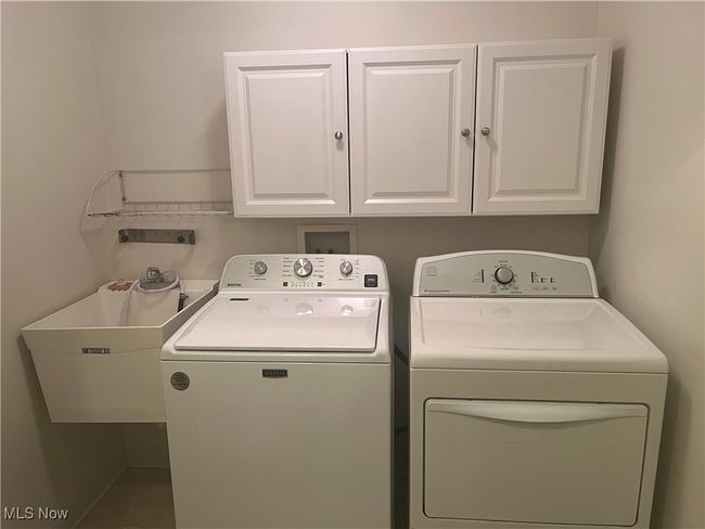 Laundry room is in the hallway hidden behind accordian doors. Washer (2023) .. Electric Dryer (2015) and so nice to have cabinets and a sink. | Image 17