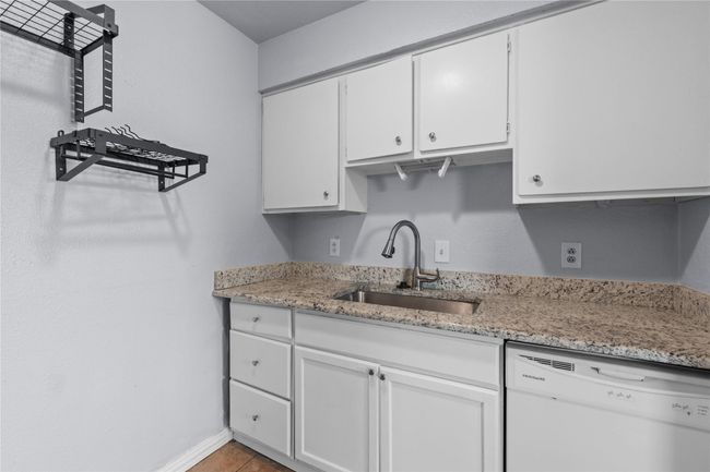 Kitchen featuring dishwasher, white cabinetry, and light stone counters | Image 13