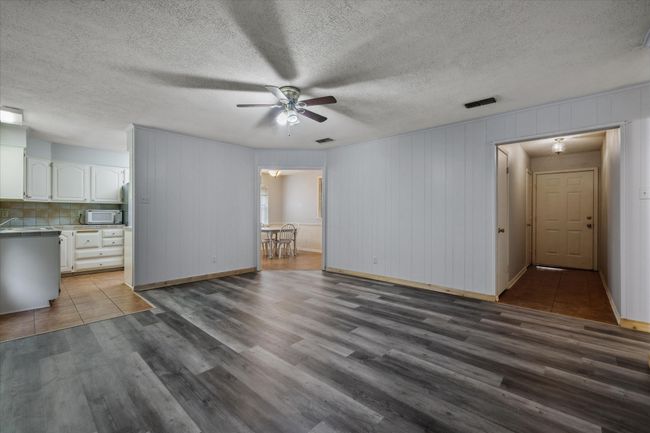 Unfurnished living room featuring a ceiling fan, wood finished floors, and a textured​​‌​​​​‌​​‌‌​‌‌​​​‌‌​​‌‌​‌​​​​​‌ ceiling | Image 14
