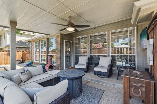 View of patio featuring a covered outdoor hangout area and a ceiling fan. | Image 28