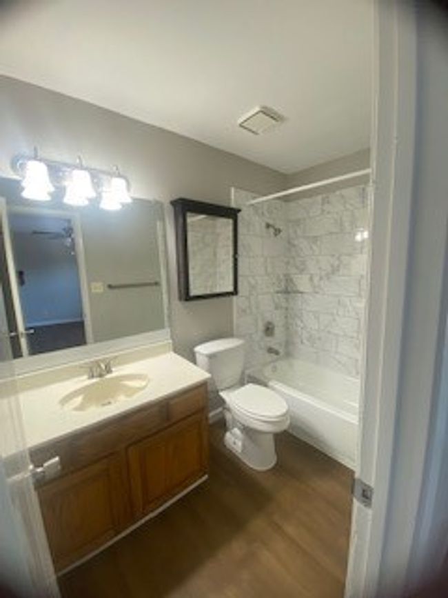 Full bath with vanity, wood finished floors, shower / bath combination, and toilet | Image 31