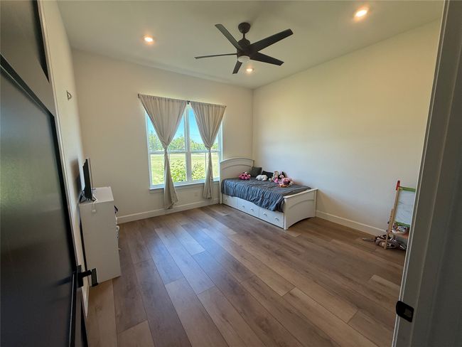 Bedroom featuring wood finished floors, recessed lighting, and a ceiling fan | Image 7