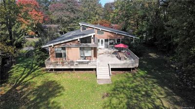 Rear view of house featuring a wooden deck and a lawn | Image 3