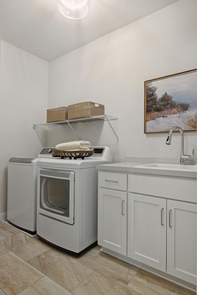Large Laundry Room with sink Plus upper cabinets (not shown); & connects to Owner's Closet! Photos may not depict actual home plan configuration. Features/materials/finishes shown contain options that are not included in price. | Image 16