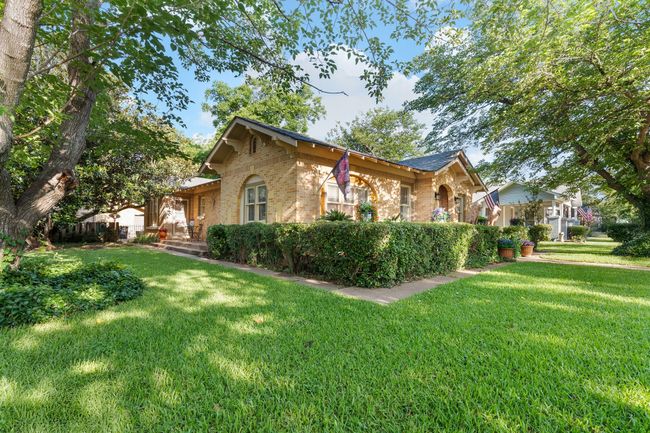 View of home's exterior featuring brick siding and a lawn | Image 4