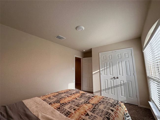 Bedroom featuring dark colored carpet and a closet | Image 8
