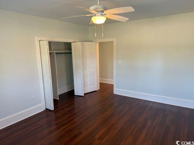 Unfurnished bedroom with a closet, ceiling fan, and dark hardwood / wood-style floors | Image 22