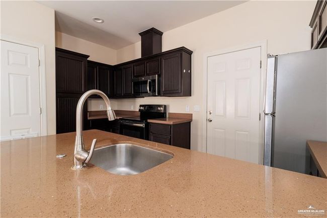 Kitchen with appliances with stainless steel finishes and light stone countertops | Image 4