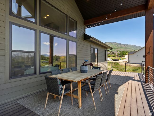 Wooden deck featuring a mountain view and outdoor dining space | Image 49