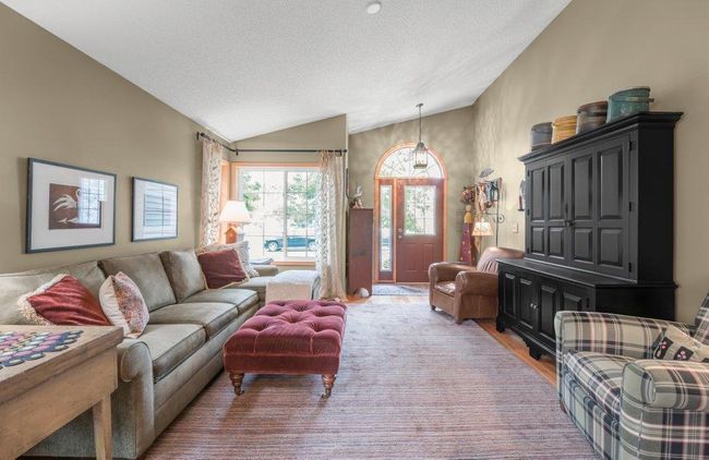 Welcoming Great Room with corner windows highlighted with Ethan Allan curtain rods, wood trim, and a vaulted ceiling. | Image 4